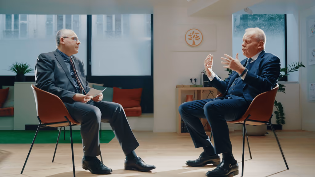 Plan large de l'interview : deux hommes assis face à face sur un plateau lumineux