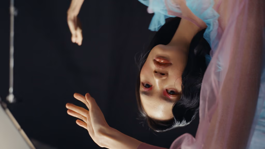 Portrait à l'envers d'une mannequin entourée de tulle rose, shooting Fujifilm « Color Balance »
