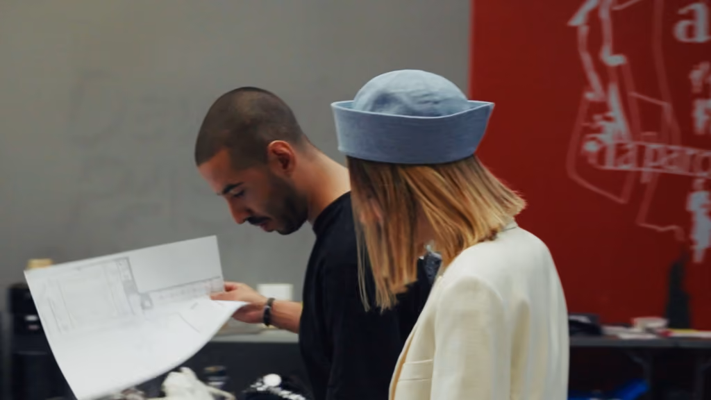 Étudiants consultant un plan en coulisses du défilé Istituto Marangoni