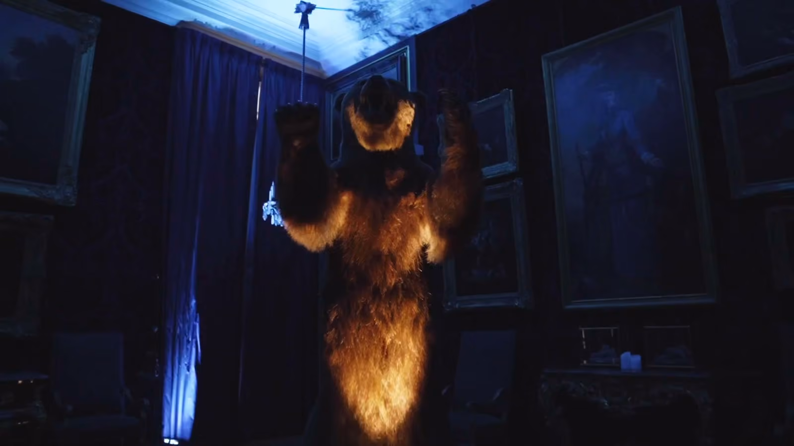 Un costume d’ours suspendu sous une lumière bleue