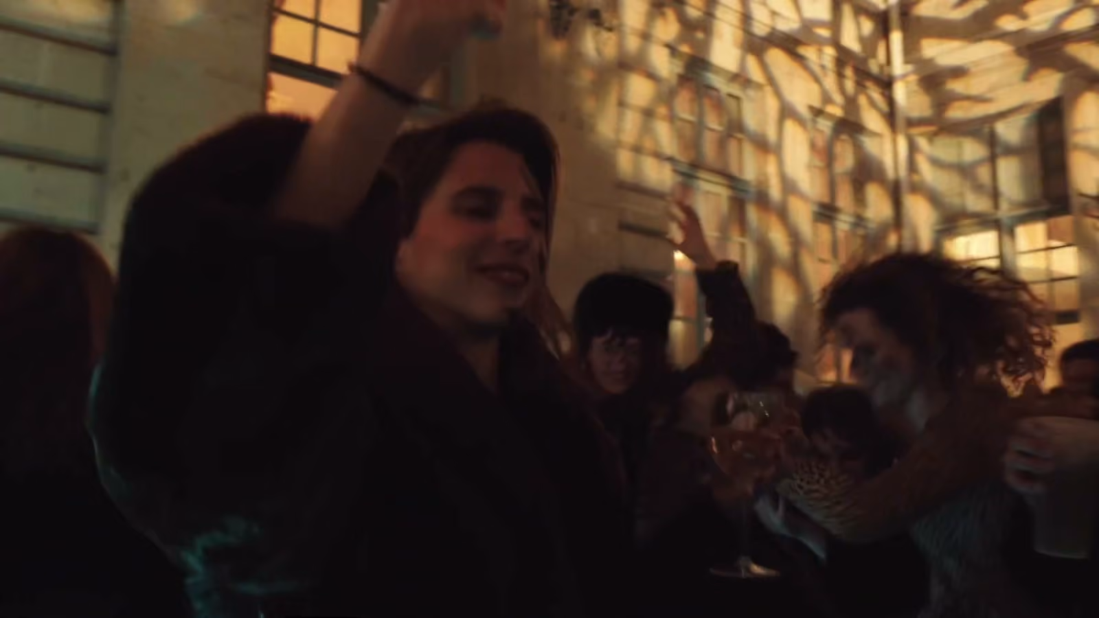 La foule danse dans la cour du musée, sous des projections