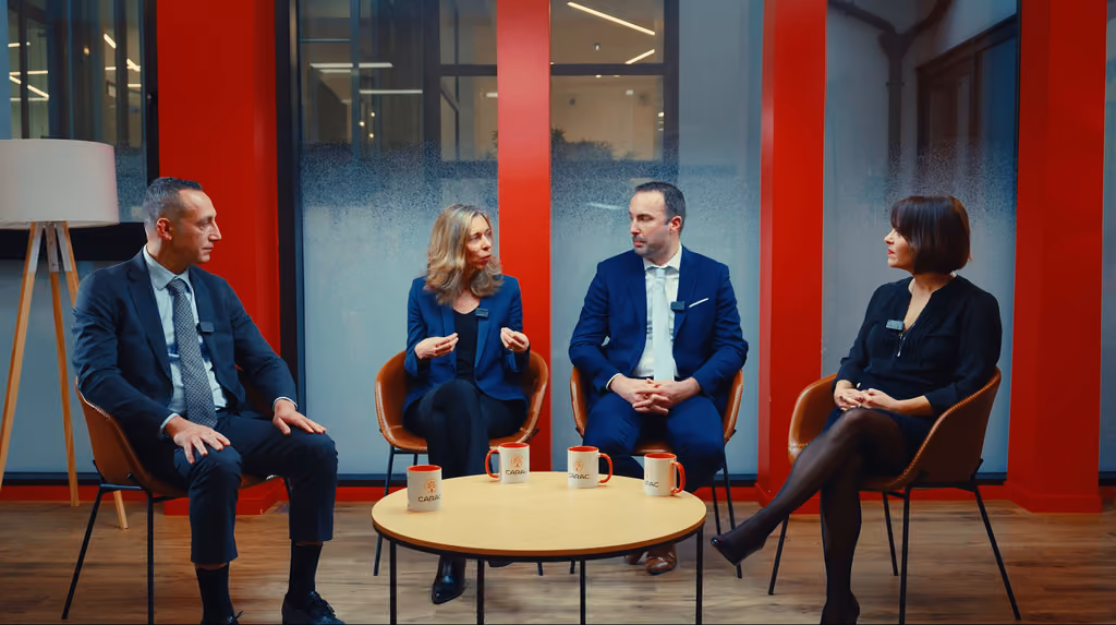 Plan large du plateau : quatre intervenants assis autour d'une table basse, webinaire multicaméra Carac
