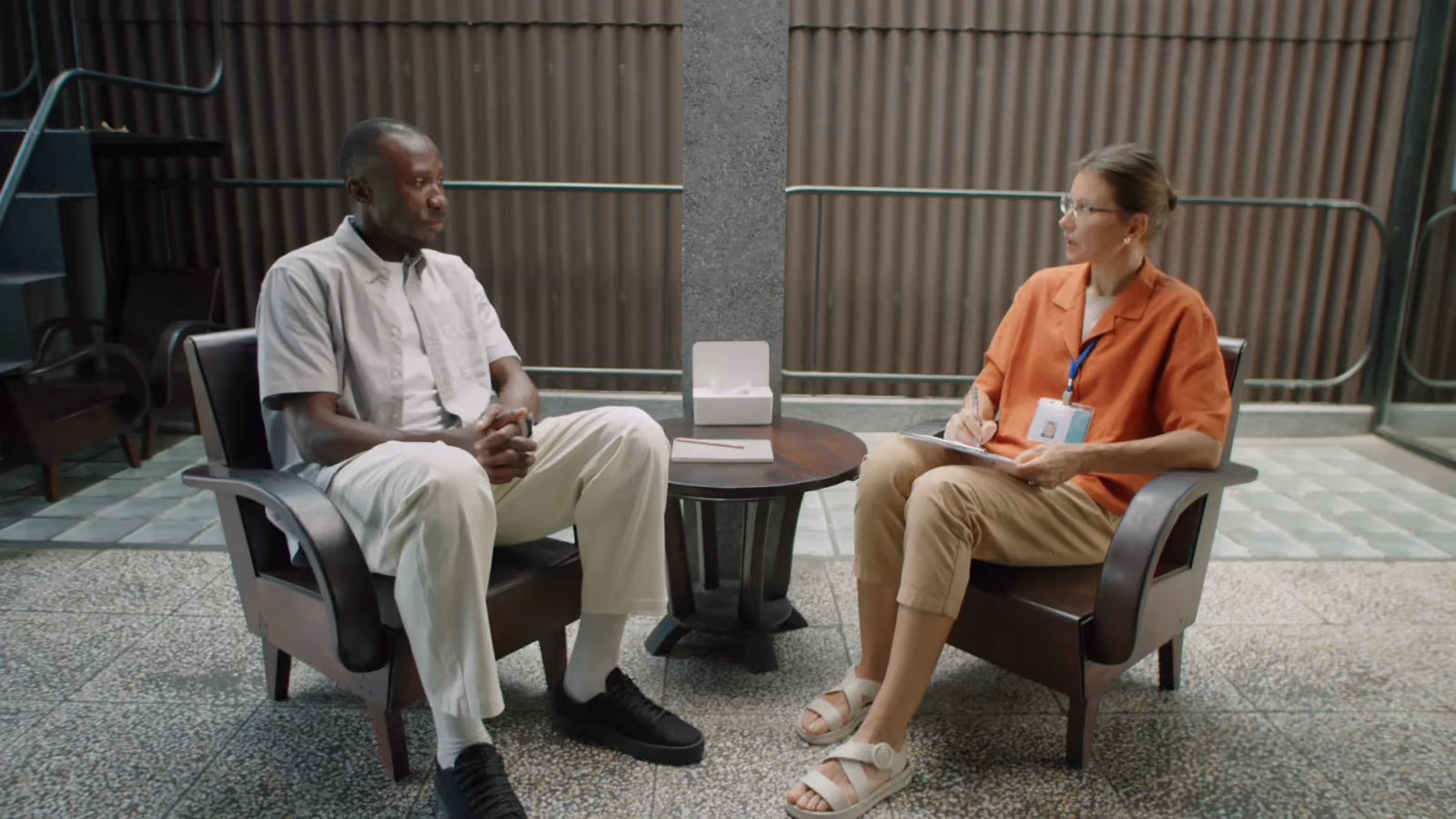 Une interview filmée : deux personnes assises face à face dans des fauteuils.