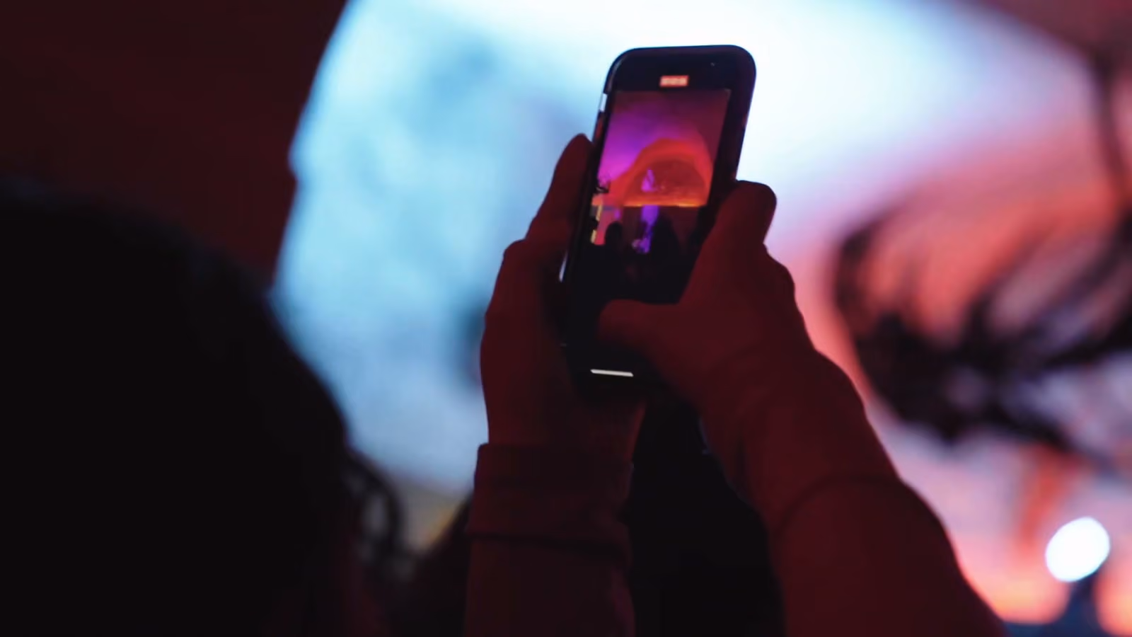 Une invitée filme une projection avec son téléphone